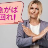 手で✕を作る女性